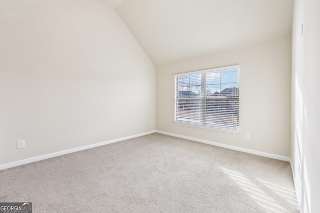 carpeted spare room with lofted ceiling