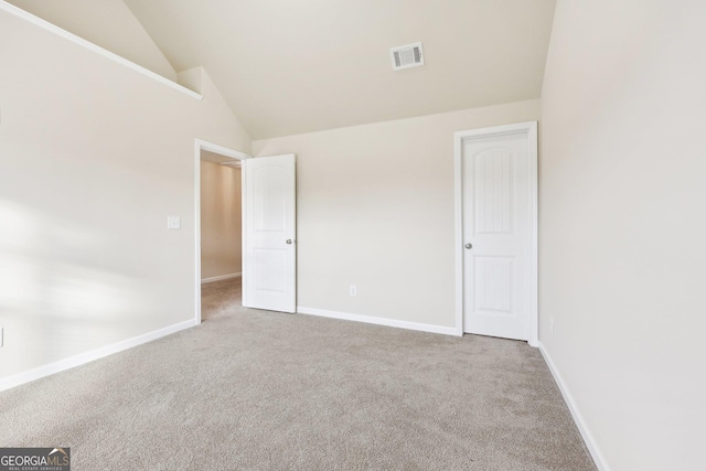 unfurnished bedroom with high vaulted ceiling and light colored carpet