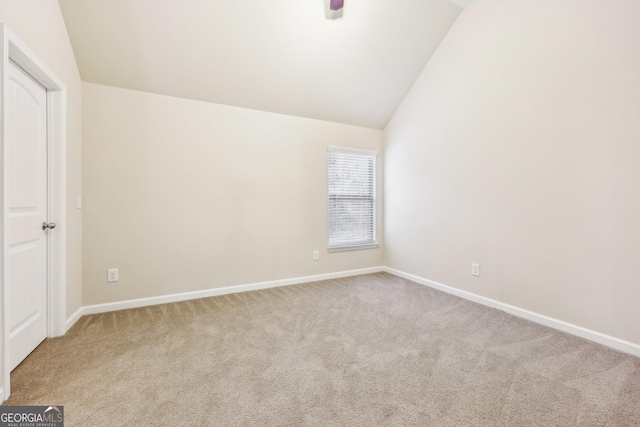 carpeted empty room with lofted ceiling