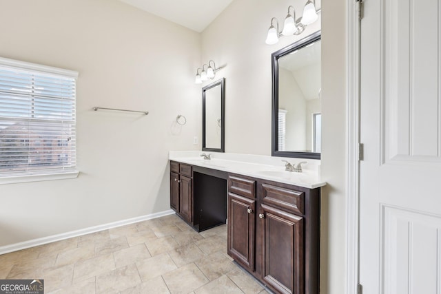 bathroom featuring vanity and lofted ceiling