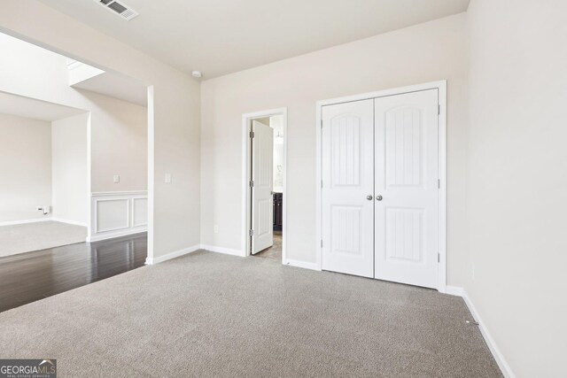 unfurnished bedroom featuring carpet and a closet