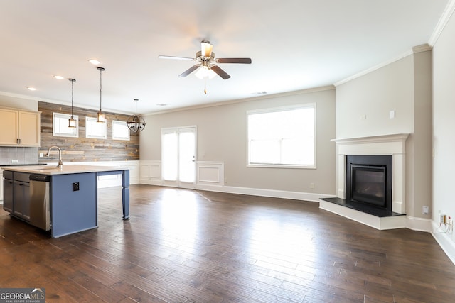 kitchen with stainless steel dishwasher, ceiling fan, an island with sink, decorative light fixtures, and a breakfast bar area