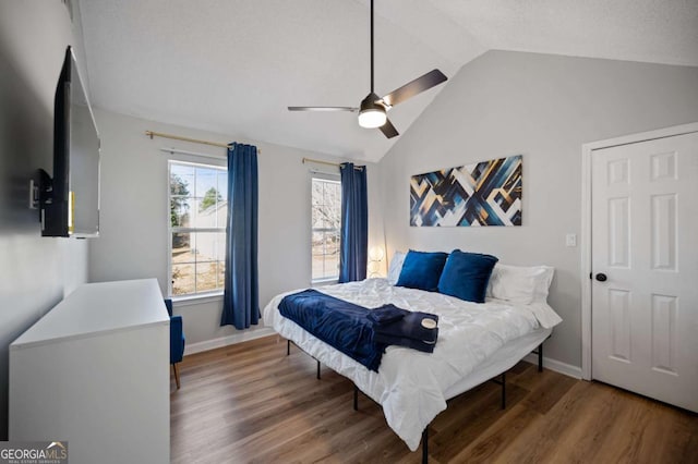 bedroom with ceiling fan, wood-type flooring, and lofted ceiling