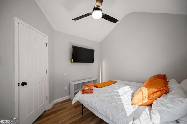 bedroom featuring ceiling fan, dark hardwood / wood-style floors, and lofted ceiling