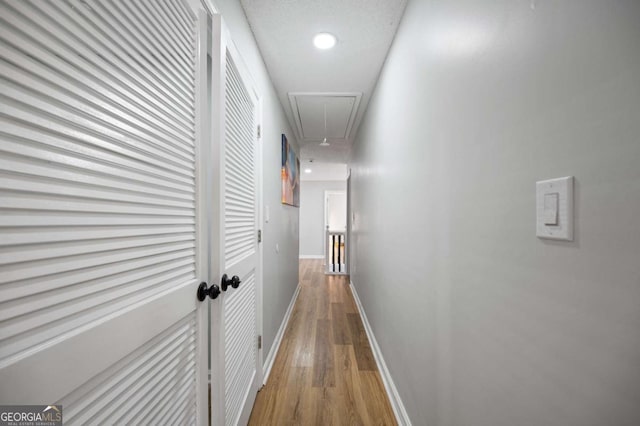 hall with wood-type flooring and a textured ceiling