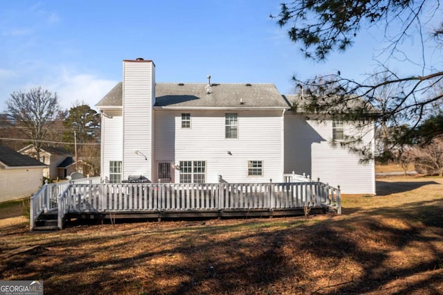 back of house featuring a deck and a yard