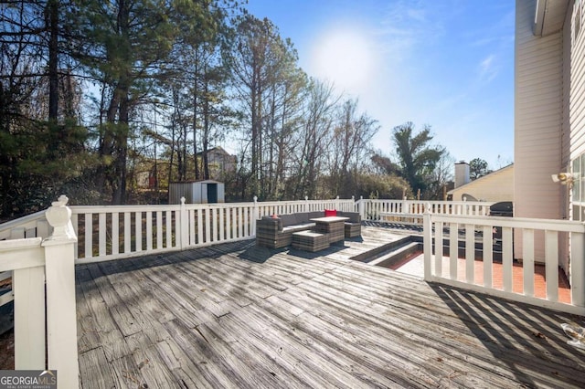 deck featuring outdoor lounge area and a storage shed