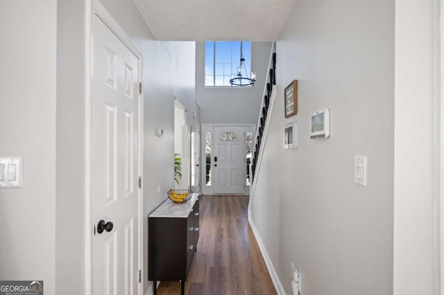 hallway with a textured ceiling and dark hardwood / wood-style floors