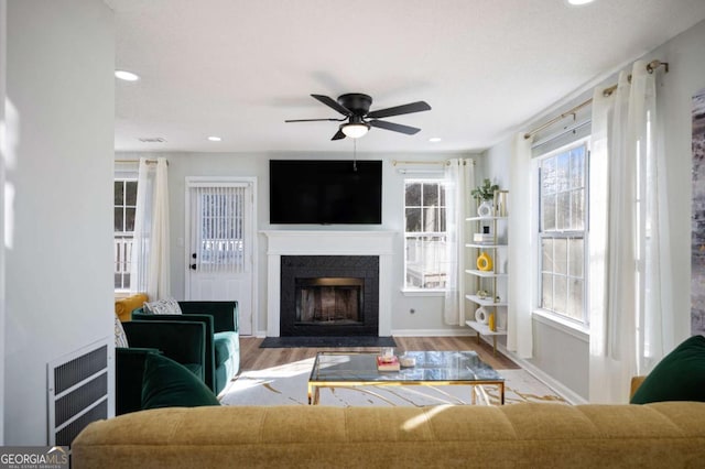 living room featuring light hardwood / wood-style flooring and ceiling fan