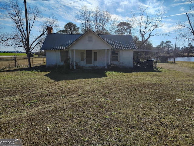 view of front of home with a porch, a water view, and a front lawn