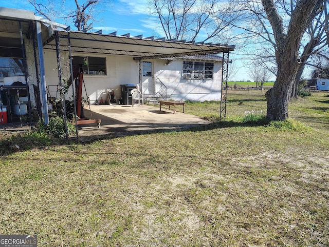 rear view of property featuring a patio area and a lawn