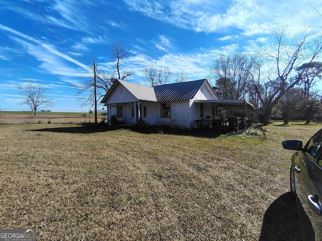 view of side of home with a lawn and a rural view