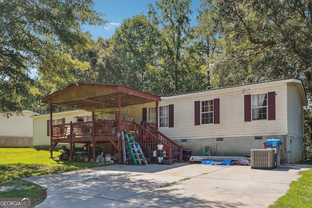 view of front of home with central air condition unit, a wooden deck, and a front yard