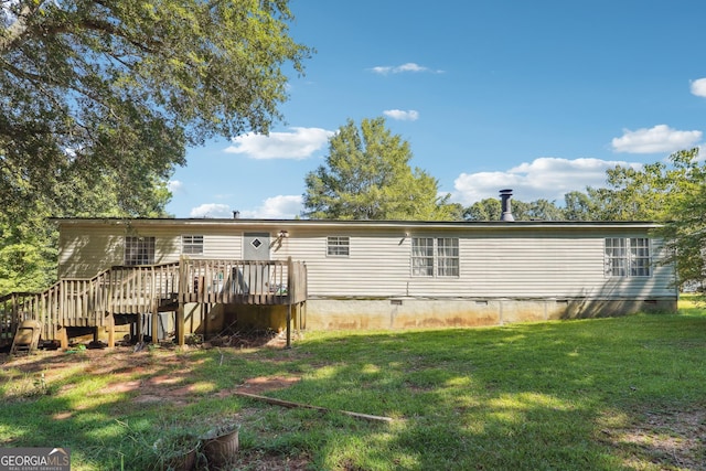 rear view of house featuring a lawn and a deck