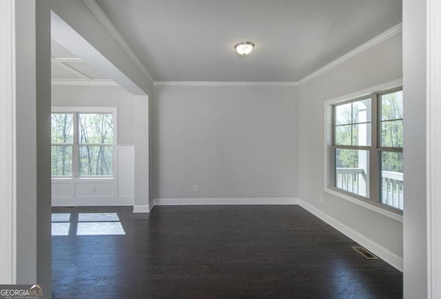 unfurnished room featuring ornamental molding, plenty of natural light, and dark hardwood / wood-style flooring