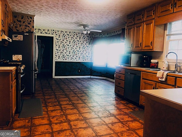 kitchen featuring ceiling fan, sink, a textured ceiling, and black dishwasher