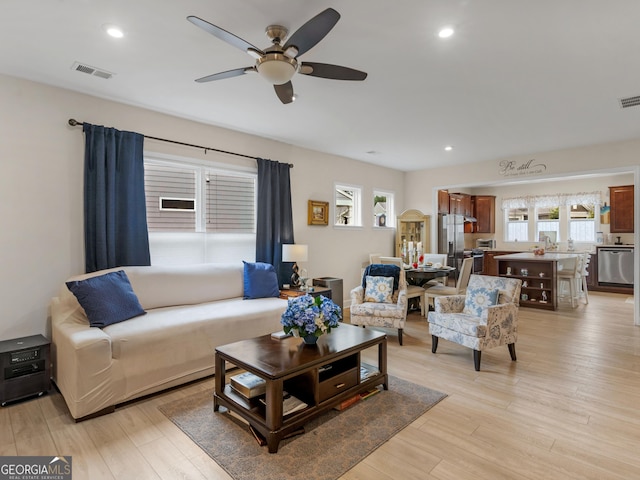 living room with light wood-type flooring and ceiling fan