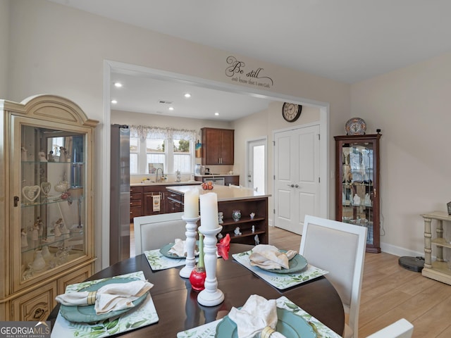 dining room with sink and light hardwood / wood-style floors