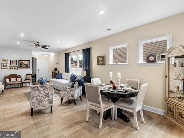 dining area with ceiling fan and light hardwood / wood-style flooring