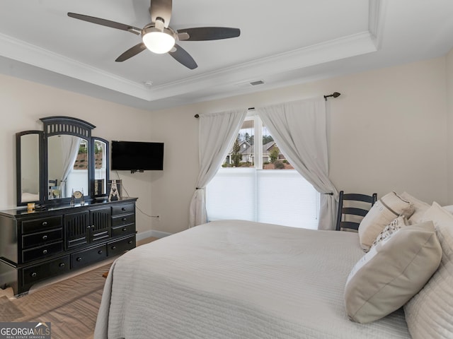 bedroom with a tray ceiling, ceiling fan, and crown molding