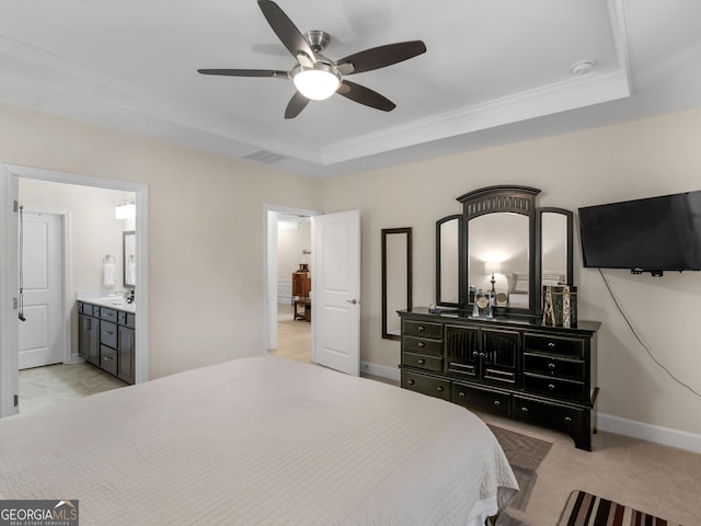 bedroom featuring ensuite bath, ceiling fan, sink, a raised ceiling, and light carpet