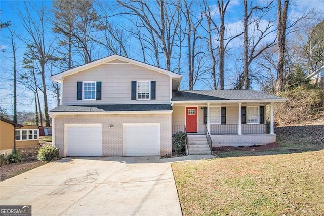 split level home with a porch, a garage, and a front yard