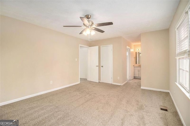 carpeted spare room with ceiling fan and a healthy amount of sunlight