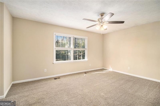 carpeted empty room with ceiling fan and a textured ceiling