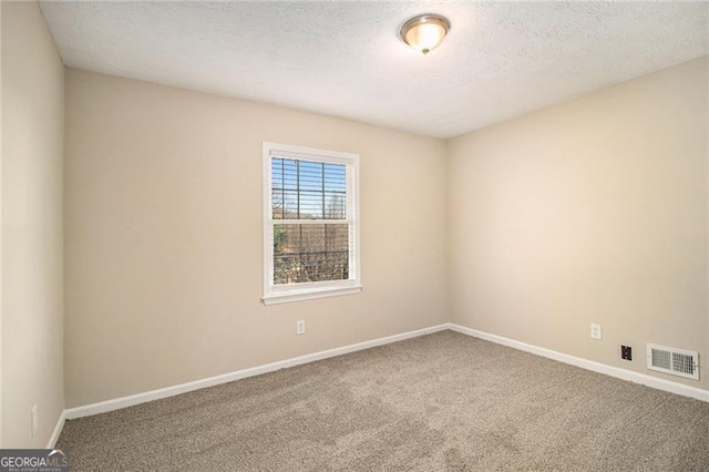 carpeted spare room featuring a textured ceiling