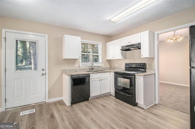 kitchen featuring light stone countertops, white cabinetry, sink, and black appliances