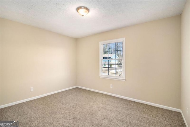 carpeted spare room featuring a textured ceiling