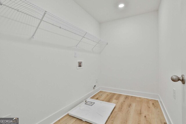 clothes washing area featuring washer hookup and hardwood / wood-style flooring