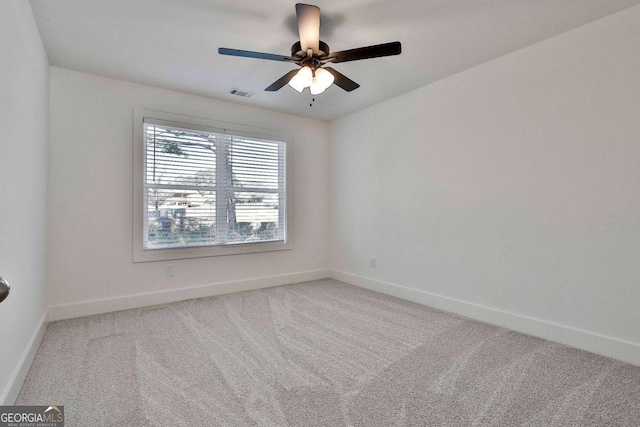 carpeted spare room with ceiling fan