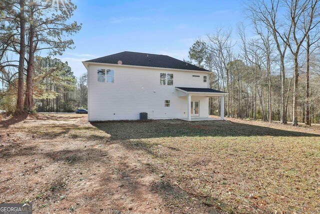 back of property with a lawn, french doors, a patio, and central AC