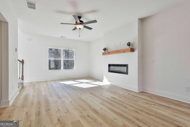 unfurnished living room featuring ceiling fan and light hardwood / wood-style flooring