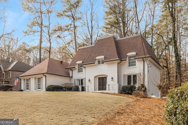 french country style house with central AC, a front yard, and french doors