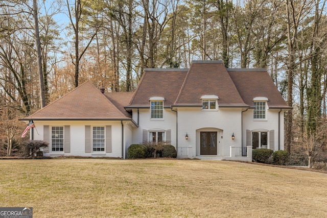 french country inspired facade featuring a front lawn