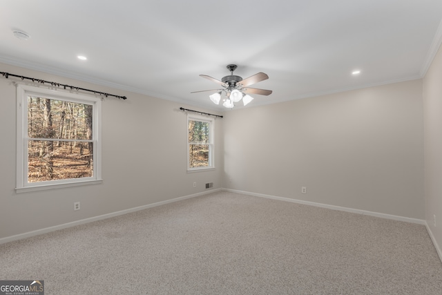 spare room featuring carpet flooring, crown molding, and ceiling fan