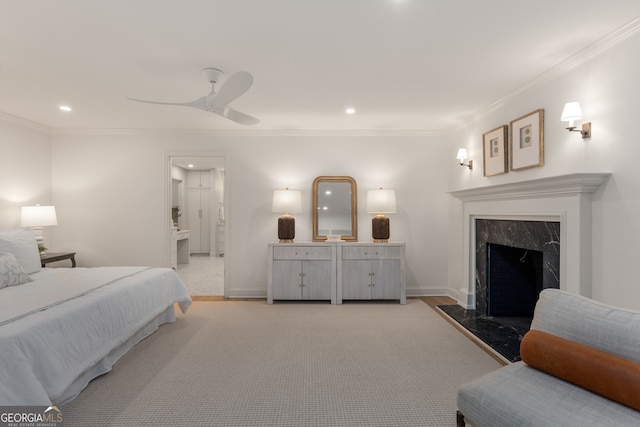 bedroom with ceiling fan, ensuite bathroom, a premium fireplace, and crown molding