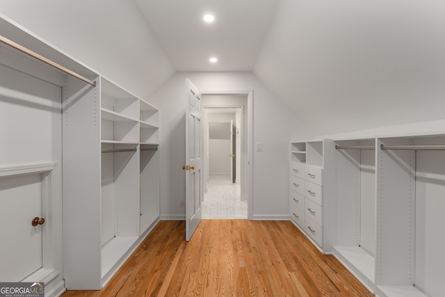 spacious closet featuring lofted ceiling and light hardwood / wood-style flooring