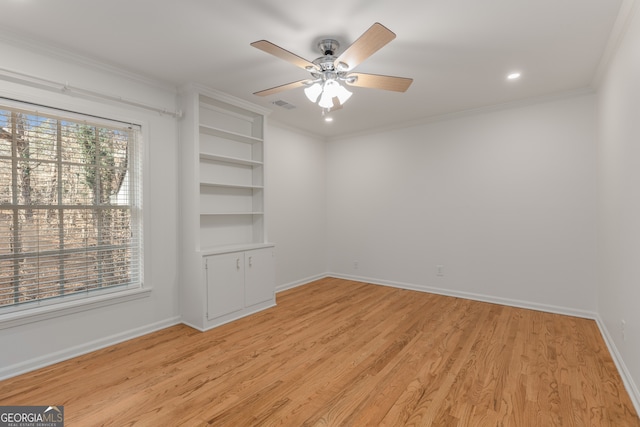 empty room with ceiling fan, crown molding, and light hardwood / wood-style floors