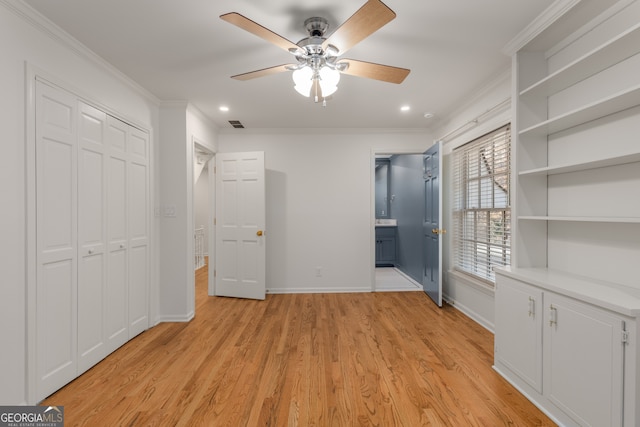 unfurnished bedroom featuring crown molding, a closet, ceiling fan, and light wood-type flooring