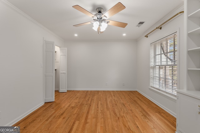 empty room with light wood-type flooring, ceiling fan, and crown molding