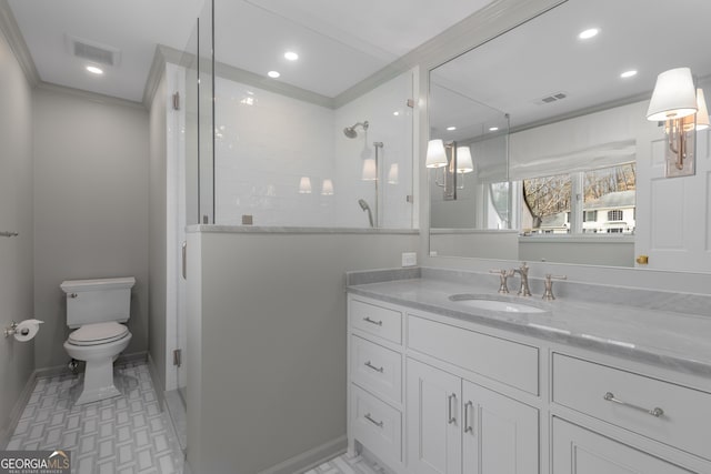 bathroom featuring crown molding, vanity, a shower with shower door, and toilet