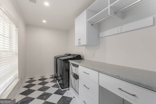 washroom featuring cabinets, independent washer and dryer, and ornamental molding