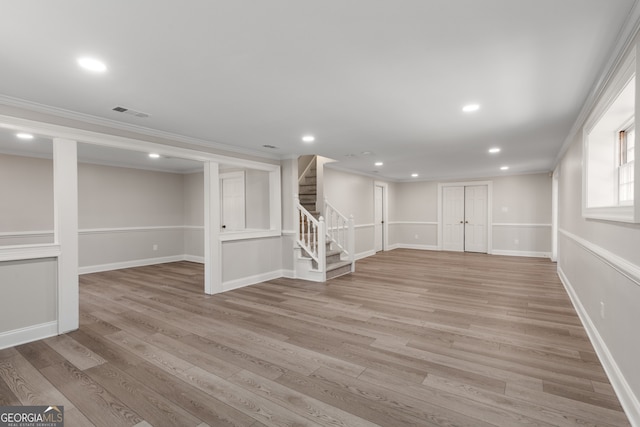 basement featuring light hardwood / wood-style flooring and ornamental molding