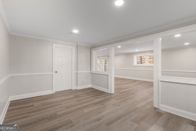 basement featuring light wood-type flooring and crown molding