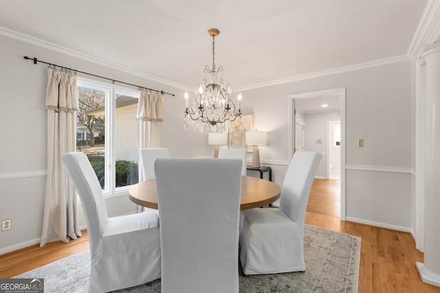 dining area featuring light hardwood / wood-style floors, ornamental molding, and a chandelier