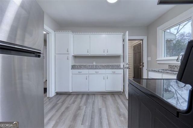 kitchen with white cabinets and light hardwood / wood-style floors