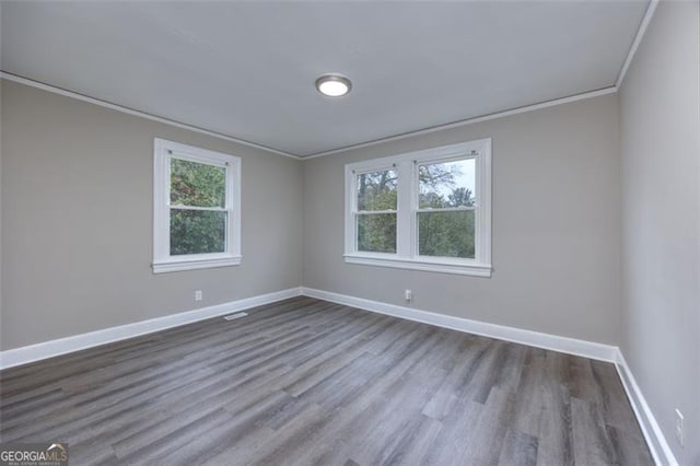 spare room with hardwood / wood-style floors and crown molding